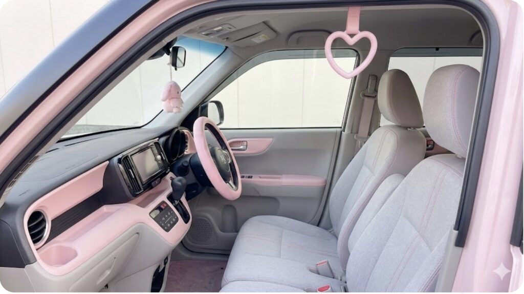 車内のカラーコーディネートに合わせて、助手席側のアシストグリップにおしゃれに飾られたピンクのハート型つり革。